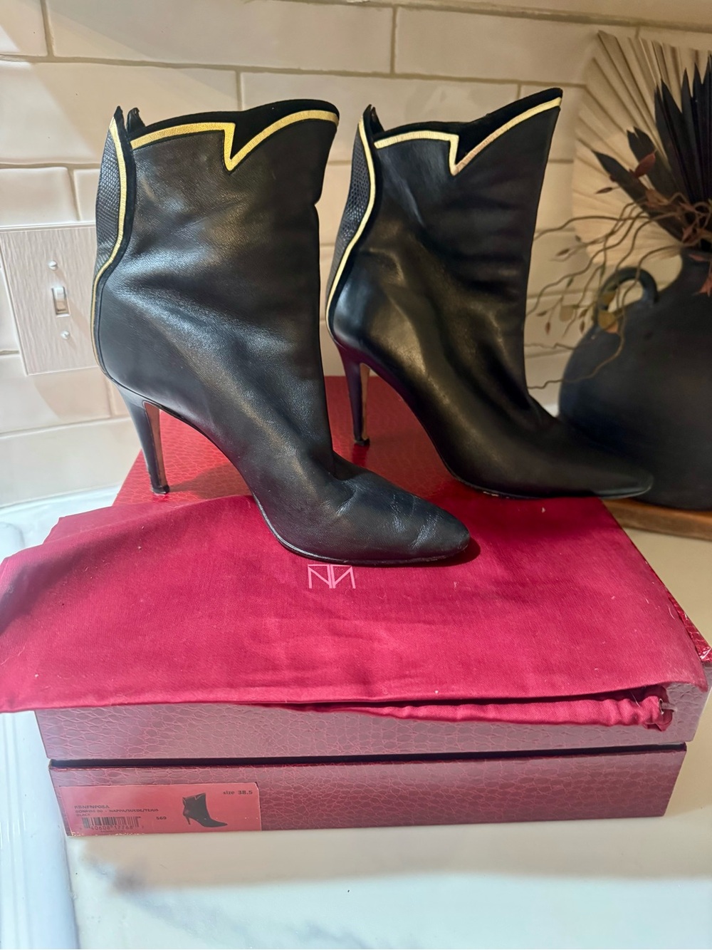 Tamara Mellon Bonfire Nappa. Black Leather High-Heel Ankle Boots with Gold Trim.